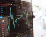Detailed view of financial trading graphs on a monitor, illustrating stock market trends.